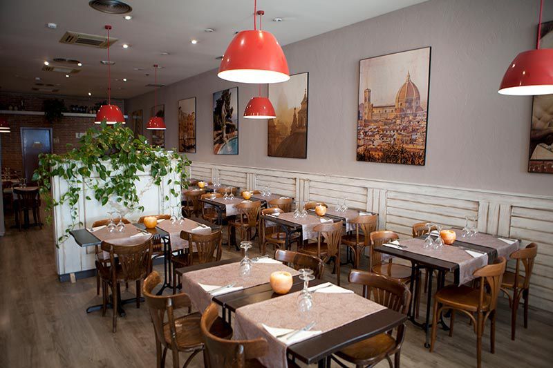 Interior de restaurante italiano con mesas de madera