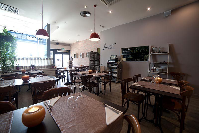 Zona interior del comedor, con mesas de madera